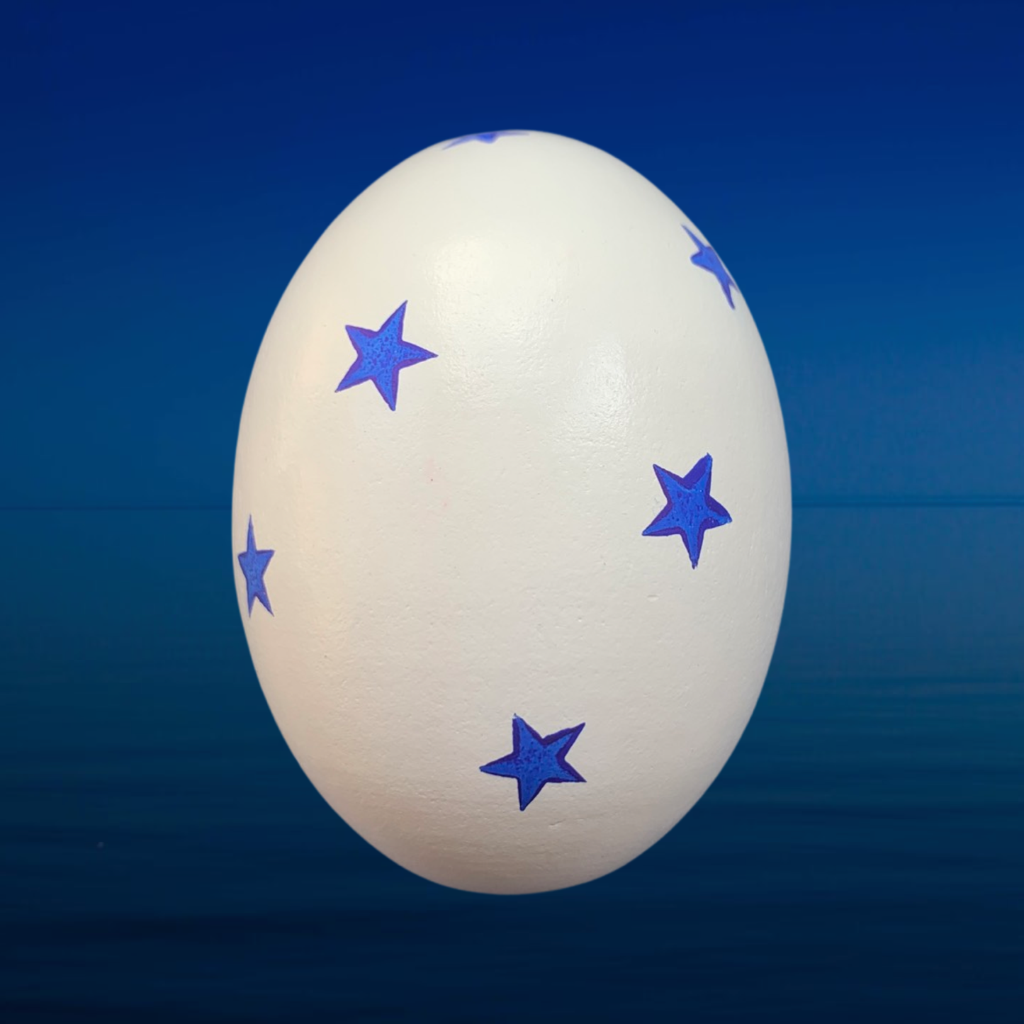 Hand painted wooden egg with blue stars. All artwork in waterproof paint so wooden eggs can be used for outdoor Easter Egg hunts.  Perfect for egg hunts, home decor or table decorations for Easter lunches.  Size of a regular hens egg.